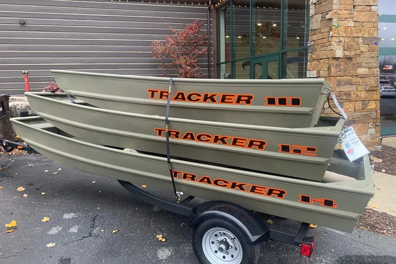 The Image of 2024 Tracker Grizzly 1036 Jon boats stacked on a trailer outside a building. - 0