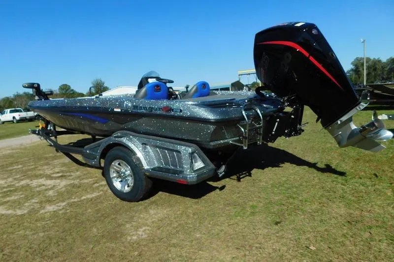 Slide: The Image of 2024 Ranger Z518 boat on trailer, metallic finish, outboard motor, parked on grass. - 6