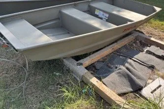 The Image of 2024 Tracker Grizzly 1036 Jon boat on wooden support, outdoors. - 0
