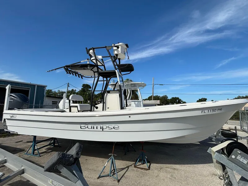 Slide: The Image of 2014 Andros Tarpon 26 boat on stands, white hull, clear sky background. - 2