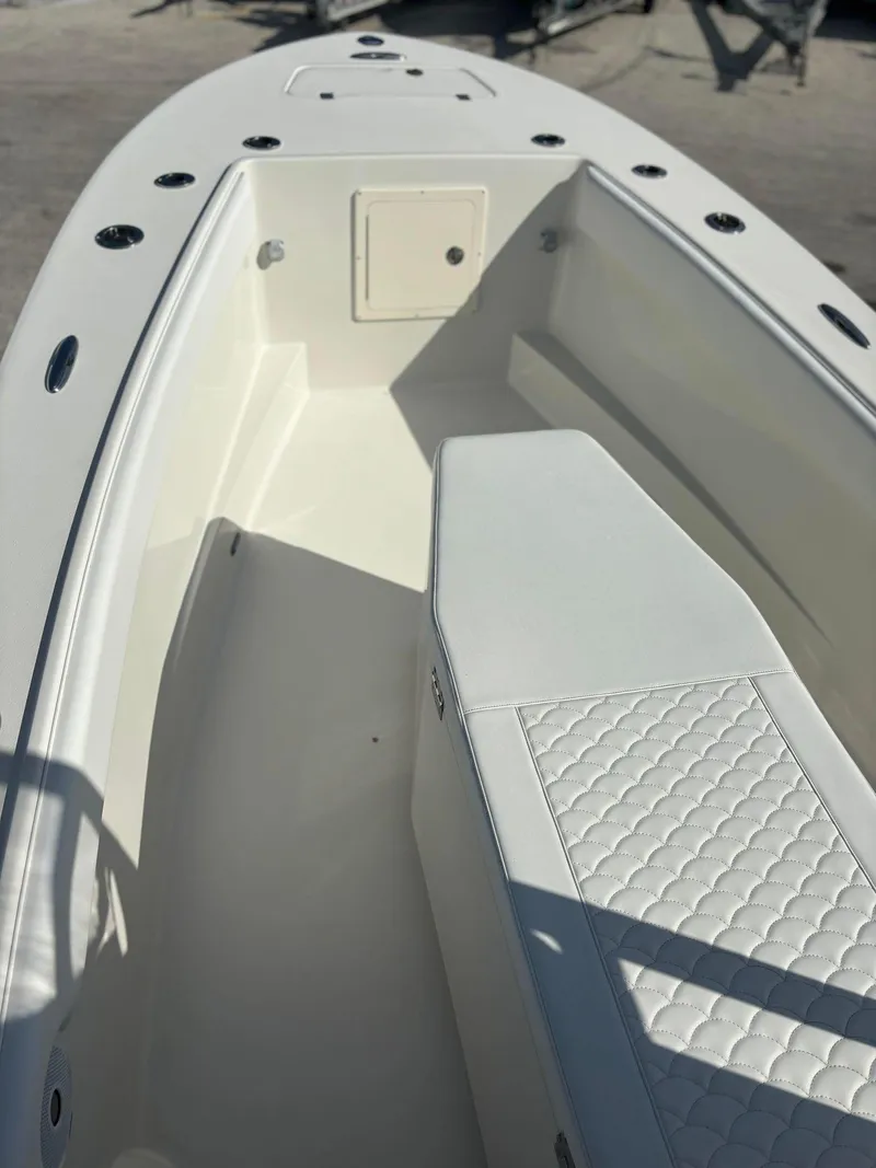 Slide: The Image of 2014 Andros Tarpon 26 boat interior with white seating and storage compartments. - 7