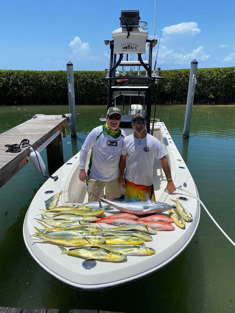 Slide: The Image of Two men on a 2014 Andros Tarpon 26 boat with a fresh fish catch. - 8