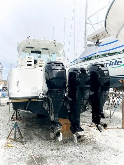 Slide: The Image of 2008 Boston Whaler 345 Conquest with triple outboard engines in a boatyard. - 12