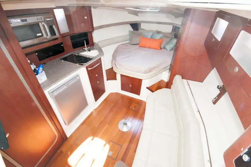 Slide: The Image of 2008 Boston Whaler 345 Conquest cabin interior with kitchen, bed, and seating area. - 15