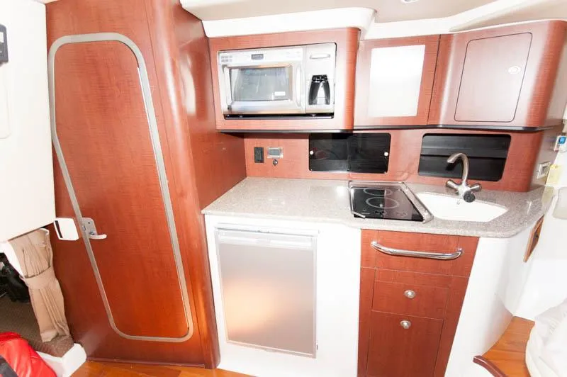 Slide: The Image of 2008 Boston Whaler 345 Conquest galley with microwave, sink, and storage cabinets. - 17