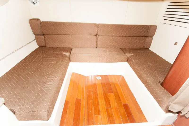 Slide: The Image of 2008 Boston Whaler 345 Conquest cabin interior with brown cushions and wooden flooring. - 19