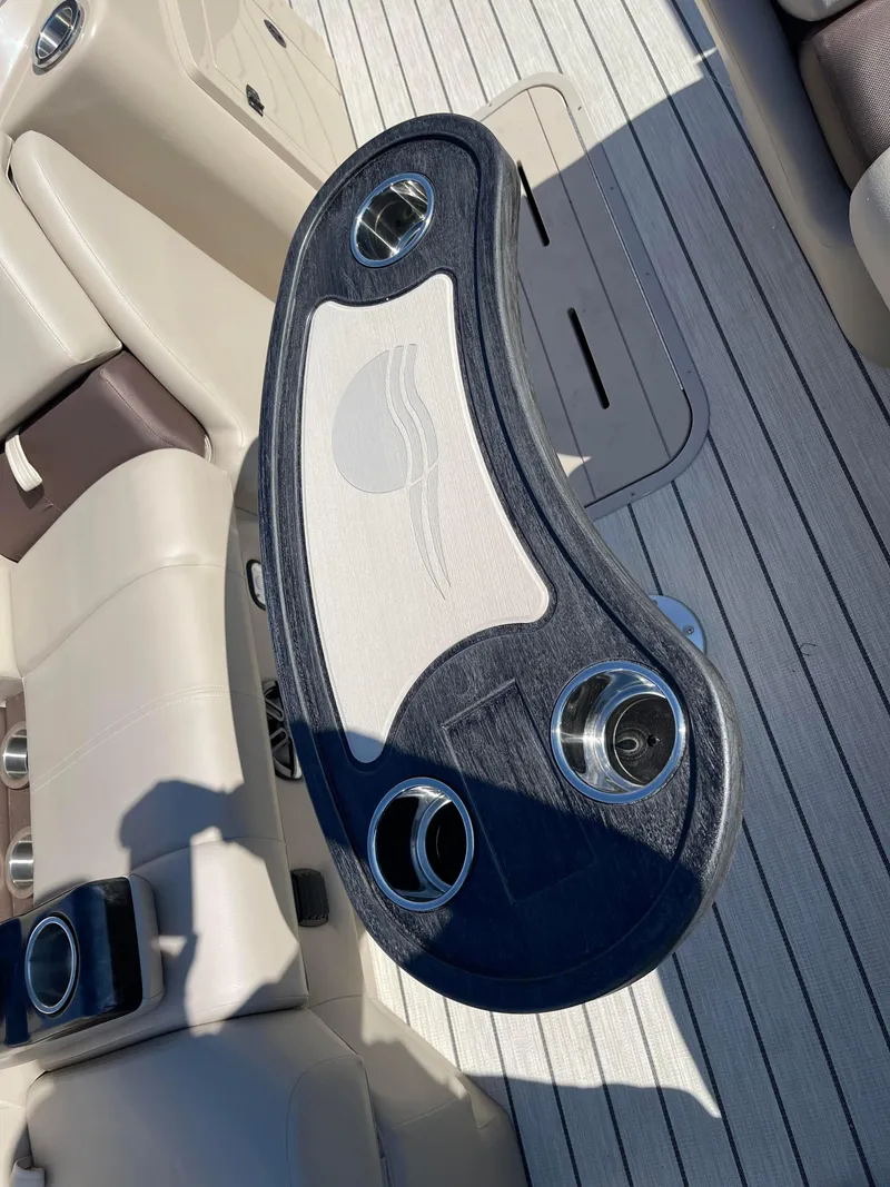Slide: The Image of 2024 SunCatcher 322rc boat interior with a stylish table and cup holders. - 14