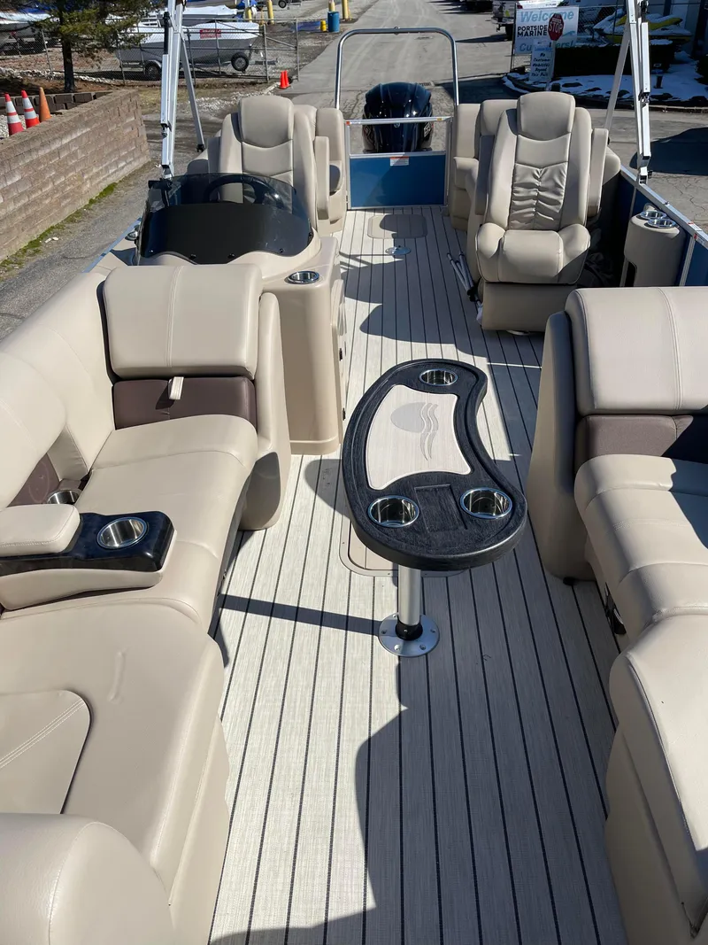 Slide: The Image of 2024 SunCatcher 322rc pontoon boat interior with beige seating and central table. - 18
