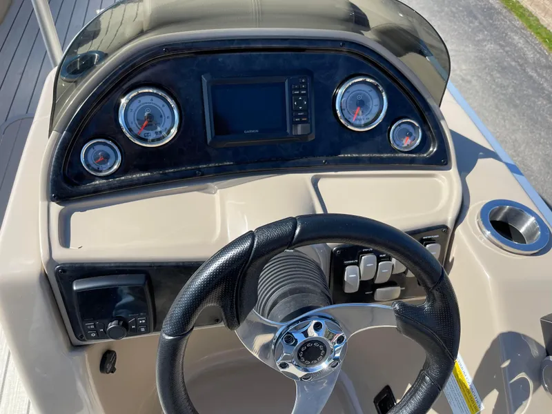 Slide: The Image of 2024 SunCatcher 322rc boat dashboard with steering wheel, gauges, and control panel. - 21