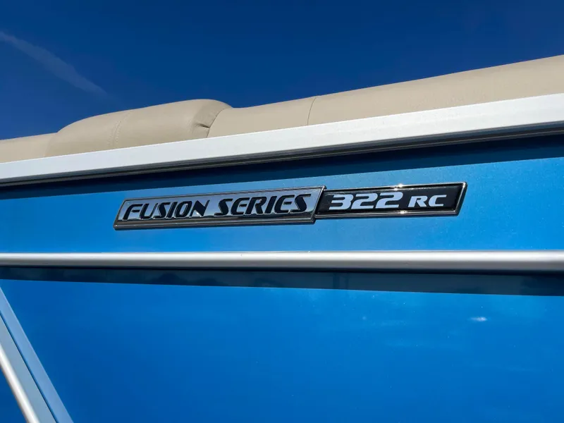 Slide: The Image of 2024 SunCatcher Fusion Series 322RC boat model emblem on blue exterior. - 3