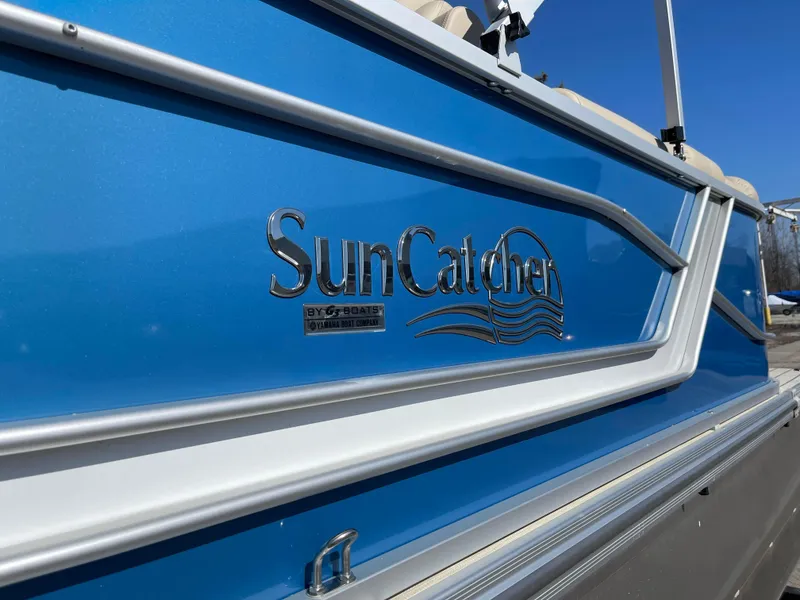 Slide: The Image of 2024 SunCatcher 322rc boat, close-up of blue exterior with logo. - 6