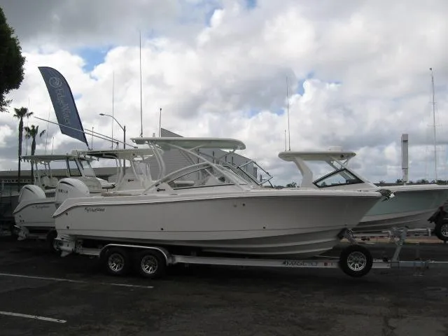 Slide: The Image of 2024 Edgewater 245CX boat on a trailer in a marina parking lot. - 1
