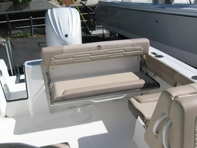 Slide: The Image of 2024 Edgewater 245CX boat interior with beige seating and outboard motor. - 3