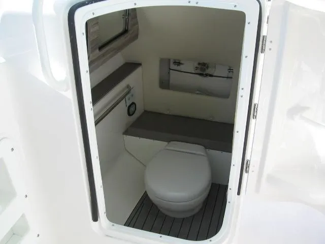 Slide: The Image of 2024 Edgewater 245CX boat interior bathroom with toilet and storage. - 6