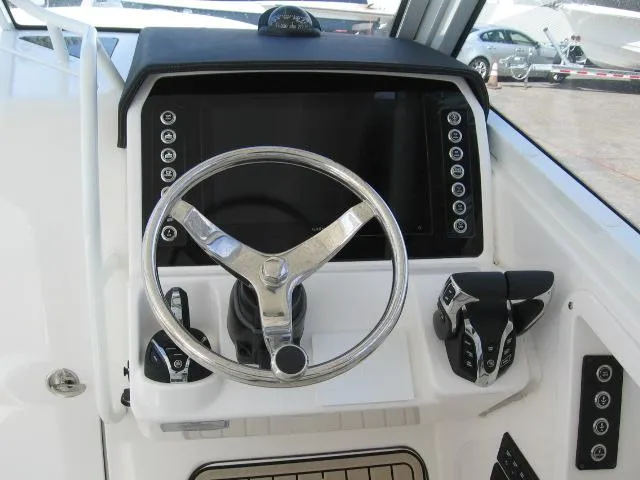 Slide: The Image of 2024 Edgewater 262 CX boat helm with steering wheel and control panel. - 11