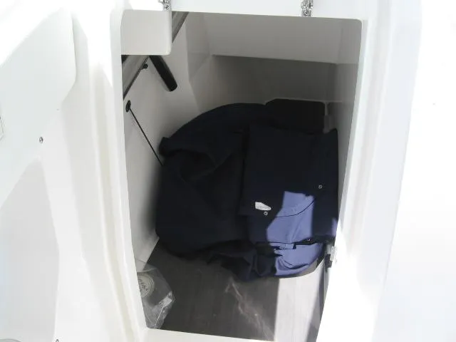 Slide: The Image of 2024 Edgewater 262 CX storage compartment with navy blue cover. - 7