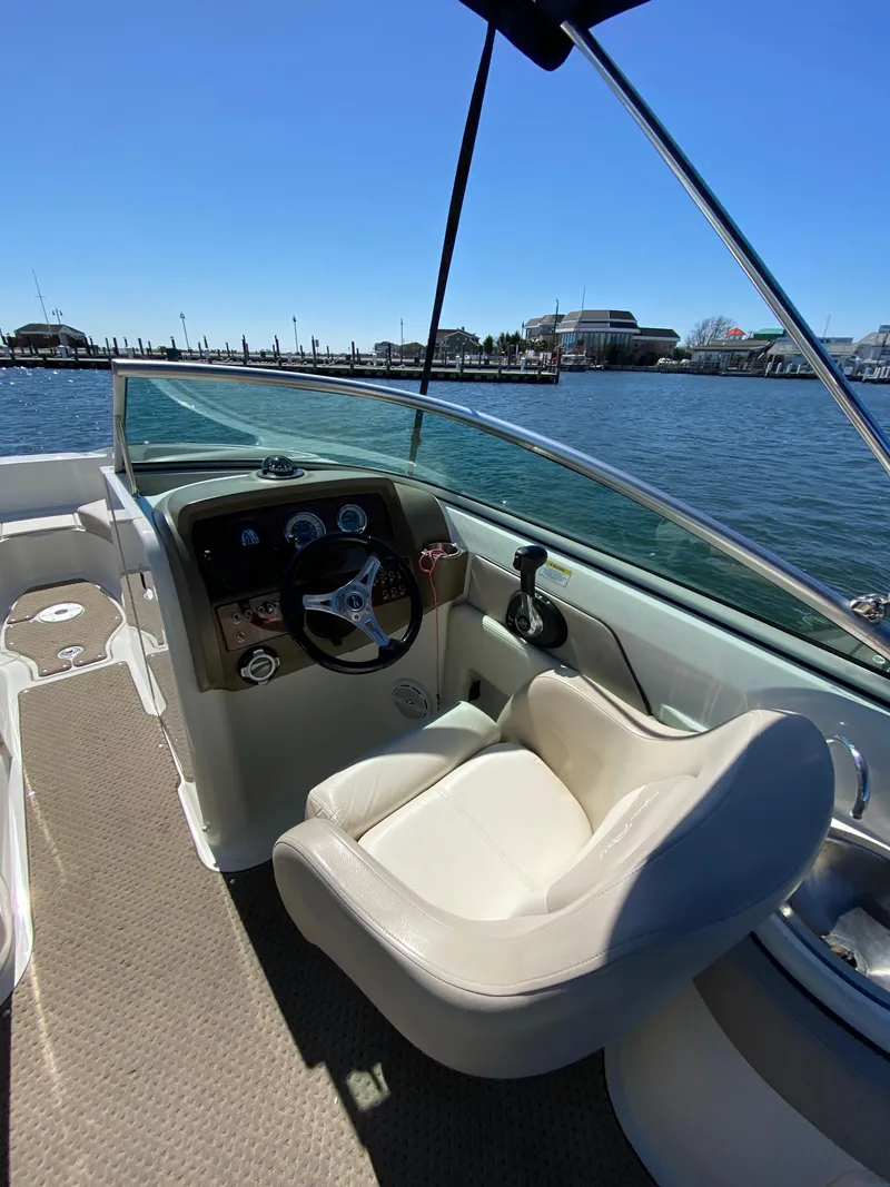 Slide: The Image of Captain's seat and dashboard of a 2011 Sea Ray 240 Sundeck boat on the water. - 10
