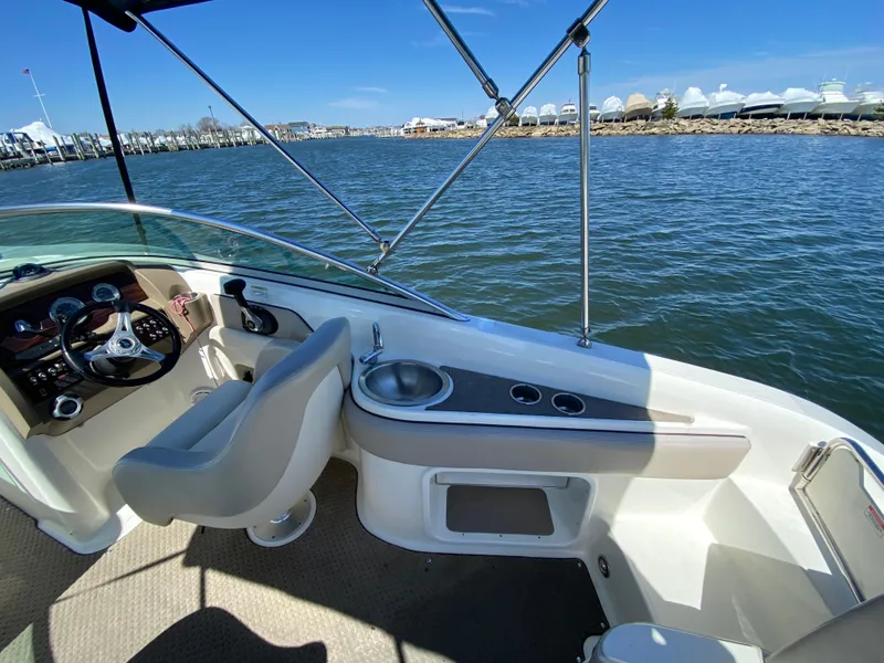 Slide: The Image of 2011 Sea Ray 240 Sundeck boat interior with steering wheel and water view. - 14