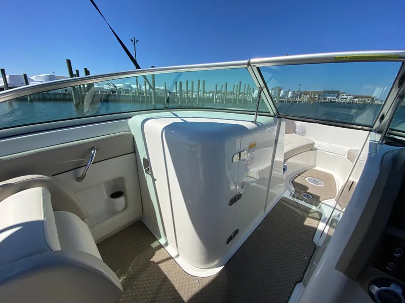Slide: The Image of 2011 Sea Ray 240 Sundeck interior with seating and storage, docked at marina. - 15