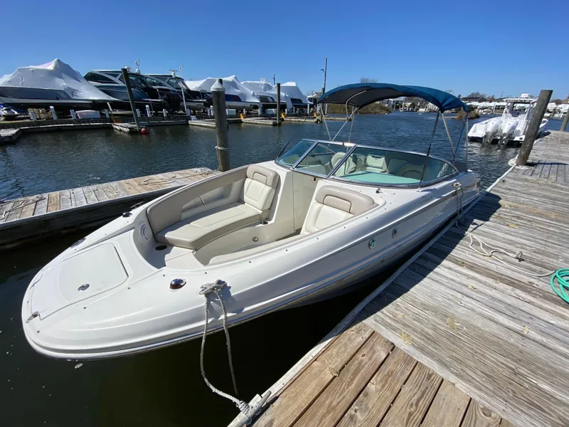 Slide: The Image of 2011 Sea Ray 240 Sundeck boat docked at a marina on a sunny day. - 19