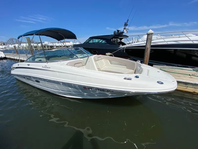 Slide: The Image of 2011 Sea Ray 240 Sundeck boat docked in marina with blue canopy. - 20