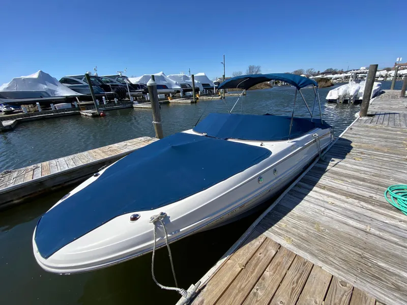 Slide: The Image of 2011 Sea Ray 240 Sundeck boat docked with blue cover and canopy. - 25