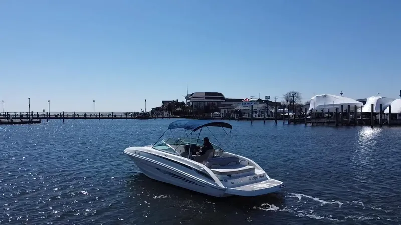 Slide: The Image of 2011 Sea Ray 240 Sundeck boat cruising near a marina on a sunny day. - 6