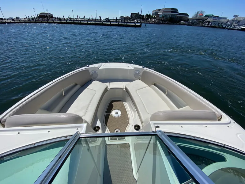 Slide: The Image of 2011 Sea Ray 240 Sundeck boat with spacious bow seating on the water. - 8
