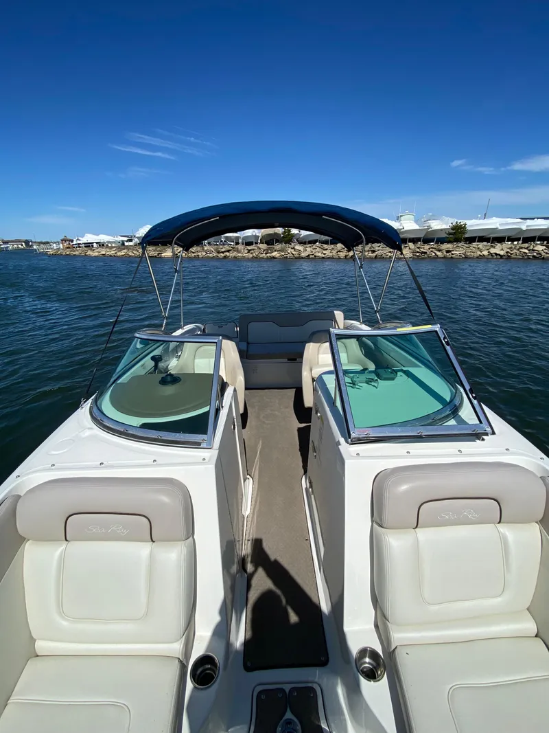 Slide: The Image of 2011 Sea Ray 240 Sundeck boat with bimini top on calm water. - 9