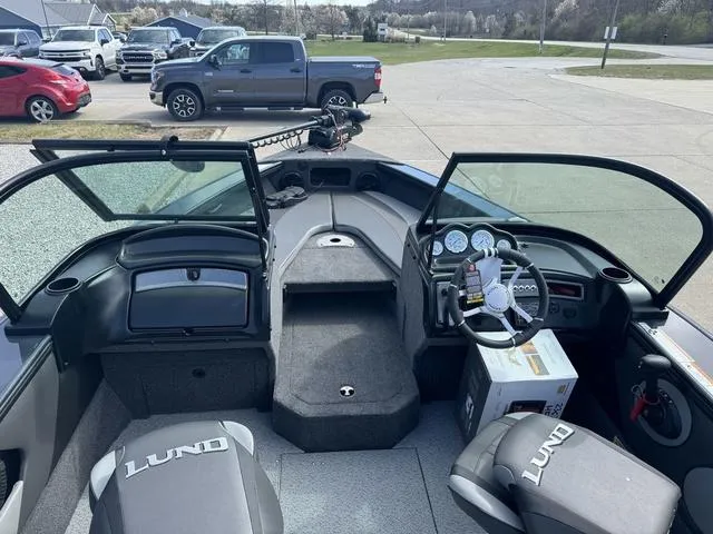 Slide: The Image of 2024 Lund 1875 Crossover XS Sport boat interior with open windshield and dashboard view. - 10
