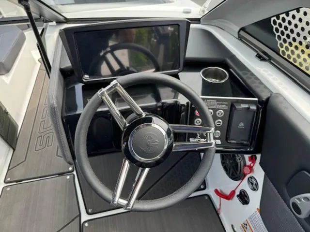 Slide: The Image of 2025 Scarab 235 Wake boat dashboard with steering wheel and control panel. - 11