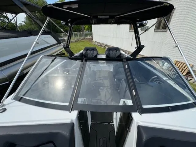 Slide: The Image of 2025 Scarab 235 Wake boat with open windshield and black canopy. - 16