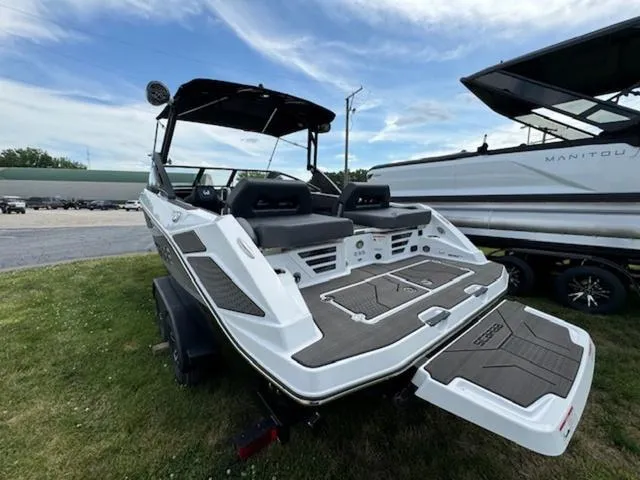 Slide: The Image of 2025 Scarab 235 Wake boat, rear view, on trailer, parked on grass. - 4
