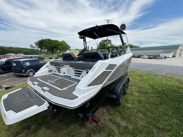 Slide: The Image of 2025 Scarab 235 Wake boat with trailer, rear view, parked on grass. - 6