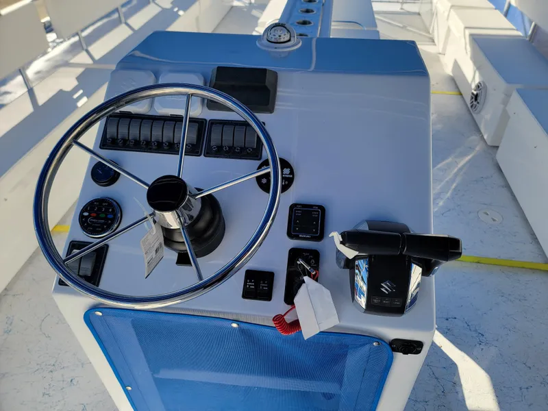 Slide: The Image of 2024 A&M Manufacturing BullDog 30 boat control console with steering wheel and throttle. - 13