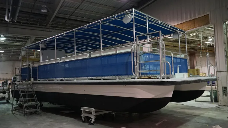 Slide: The Image of 2024 A&M Manufacturing BullDog 30 pontoon boat in a warehouse. - 5