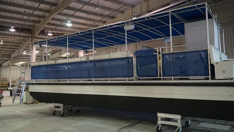 Slide: The Image of 2024 A&M Manufacturing BullDog 30 pontoon boat in a warehouse. - 6