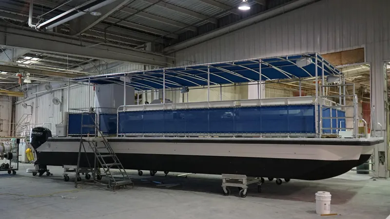 Slide: The Image of 2024 A&M Manufacturing BullDog 30 pontoon boat in a warehouse. - 7