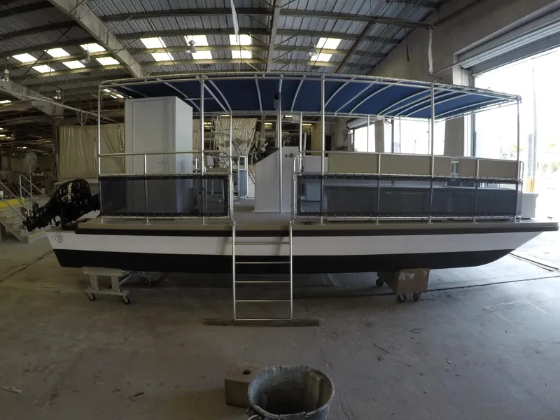 Slide: The Image of 2024 A&M Manufacturing BullDog 30 pontoon boat in a warehouse. - 8