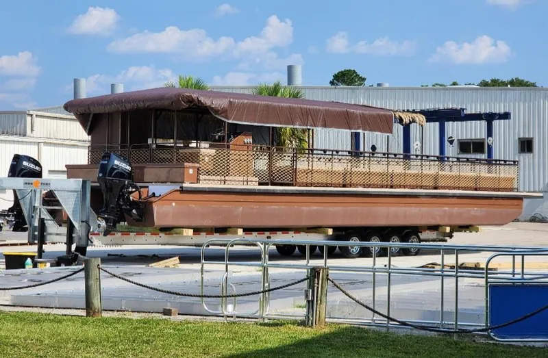 Slide: The Image of 2024 A&M Manufacturing BullDog 50 pontoon boat on trailer at industrial facility. - 10