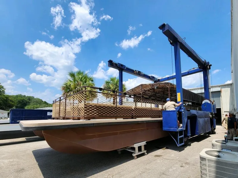 Slide: The Image of 2024 A&M Manufacturing BullDog 50 boat on a lift under a clear blue sky. - 14