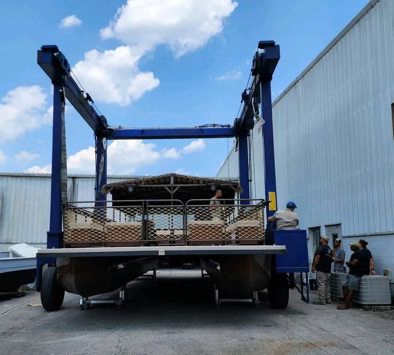 Slide: The Image of 2024 A&M Manufacturing BullDog 50 boat being lifted by a large blue crane. - 16