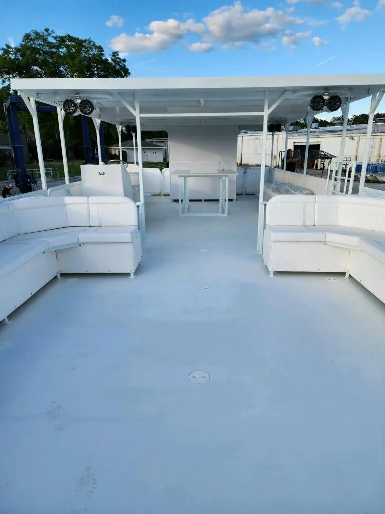 Slide: The Image of 2024 A&M Manufacturing BullDog 50 boat with spacious deck and white seating. - 22