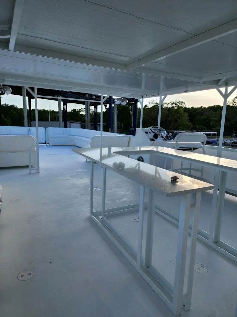 Slide: The Image of Upper deck of 2024 A&M Manufacturing BullDog 50 boat with seating and tables. - 25
