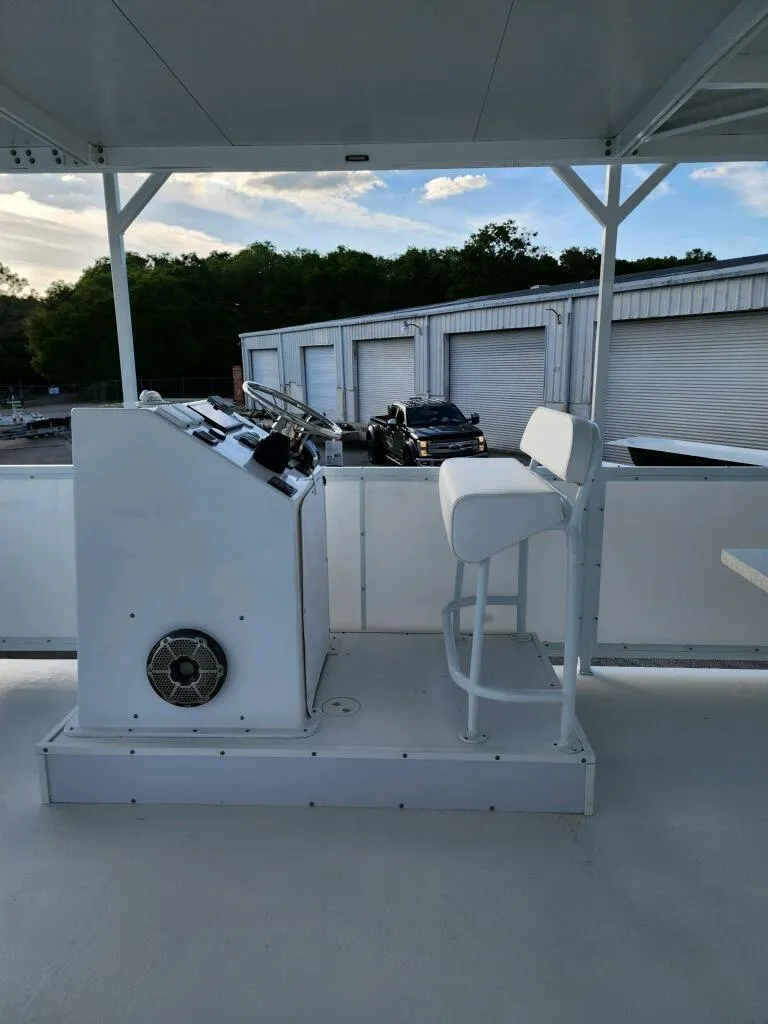 Slide: The Image of 2024 A&M Manufacturing BullDog 50 boat helm station with white captain's chair. - 26