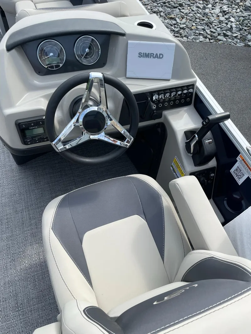 Slide: The Image of 2024 Barletta Aria 22CC boat cockpit with steering wheel and Simrad display. - 9