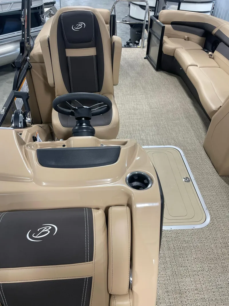 Slide: The Image of 2024 Barletta Cabrio 22Q interior, beige and black seating, steering console, and carpeted floor. - 12