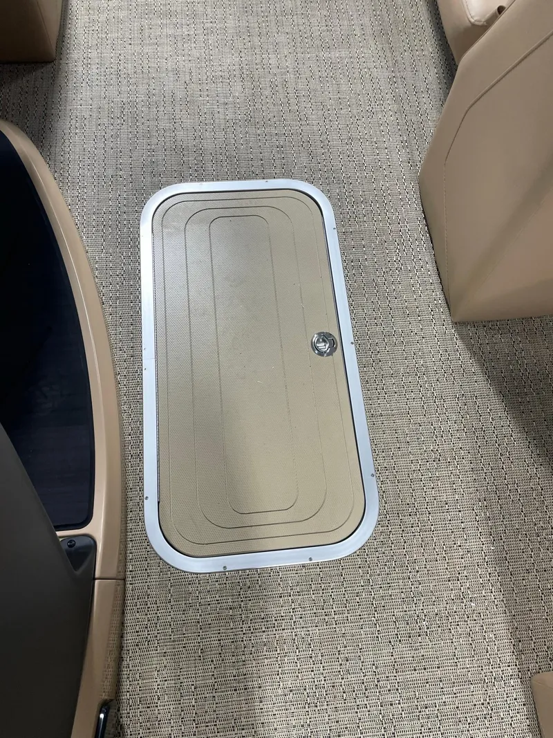 Slide: The Image of 2024 Barletta Cabrio 22Q floor storage compartment with beige carpet. - 13