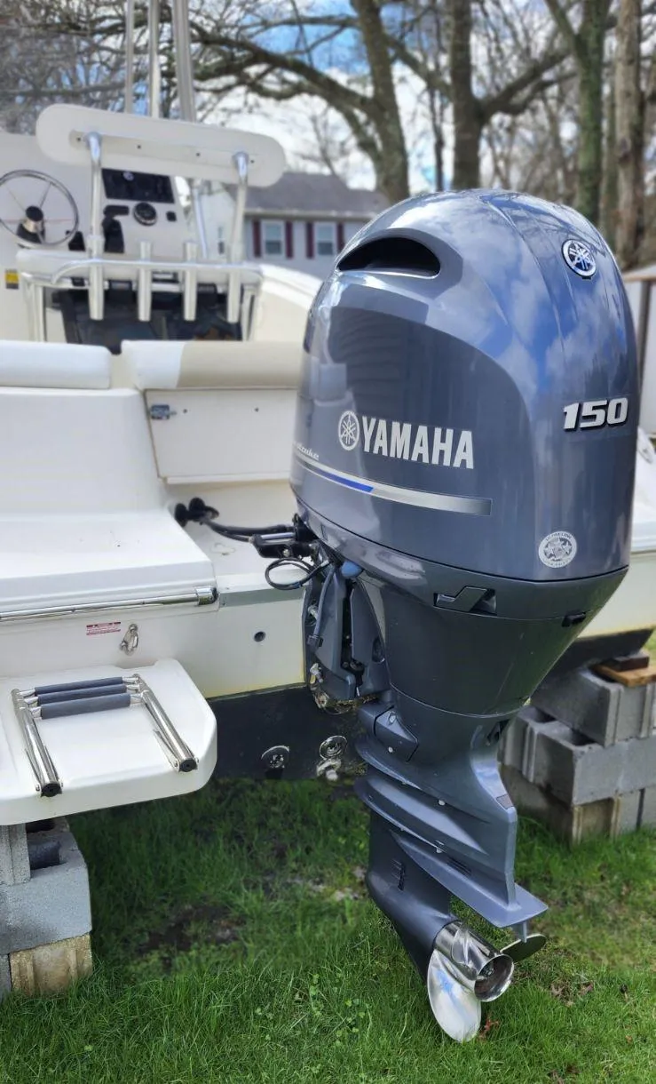 Slide: The Image of 2021 Bulls Bay 200 CC boat with Yamaha 150 outboard motor, parked on grass. - 13
