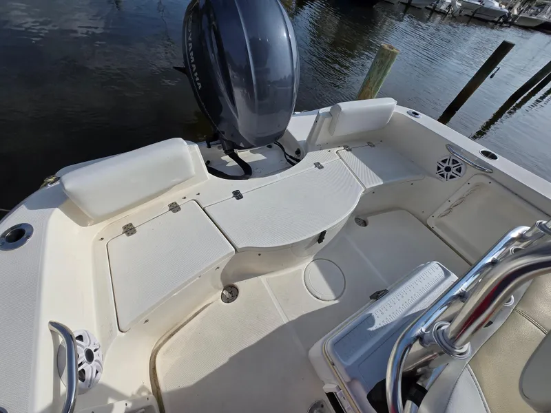 Slide: The Image of 2021 Bulls Bay 200 CC boat interior with seating and motor, docked by the water. - 22